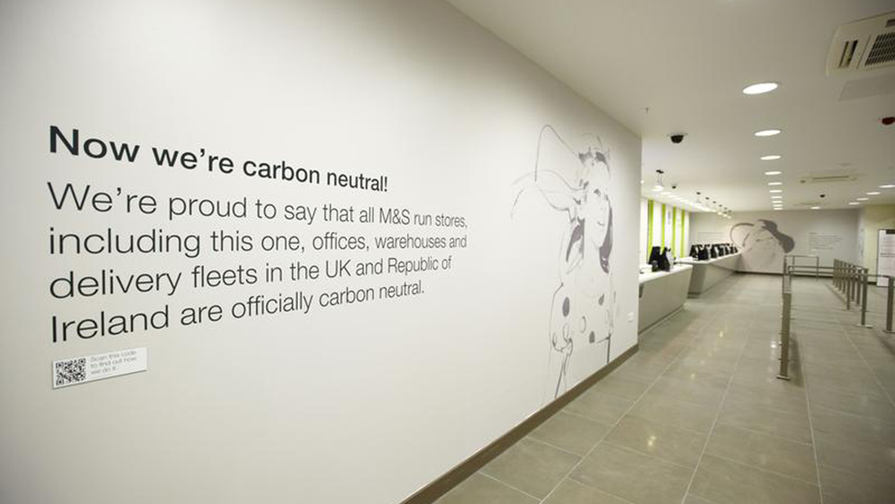 A decal on a wall in a Marks and Spencer store explains the operation is carbon neutral.